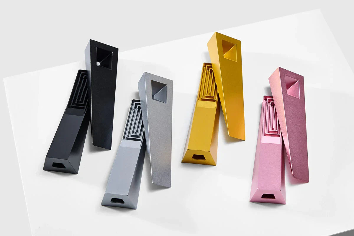 the entire Tempest designer smoking pipe lineup, with magnetic lids removed, showing off the internal labyrinth smoke pathway underneath. Shown in black Abyss, silver Mercury, gold Radiance, and pink Glimmer.